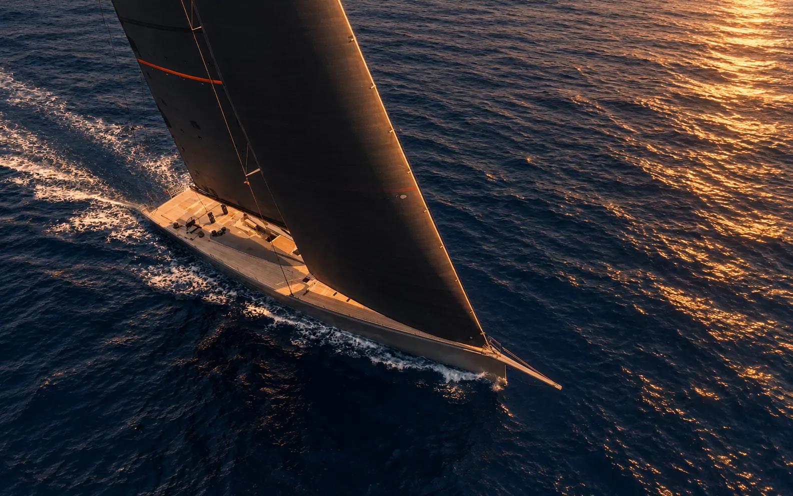 The yacht under sail at sunset, the coast behind